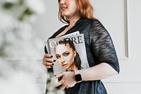 Woman wearing a smartwatch and holding a magazine