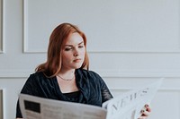 Woman reading the newspaper at home