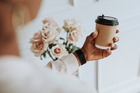 Black woman holding a coffee to go