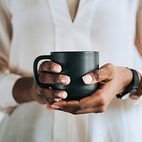 Hands holding a black cup of coffee