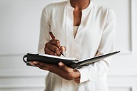 Businesswoman writing in a daily planner