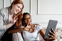 Lesbian couple having a video call with friends