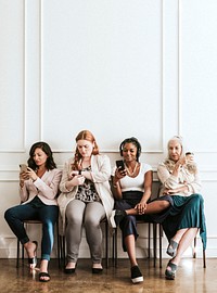 Businesswomen using digital devices while waiting