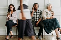 Diverse people sitting by a white wall