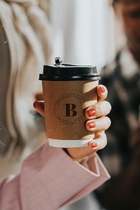 Female hand holding a coffee cup mockup