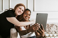 Lesbian couple taking a selfie with a digital tablet