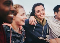 Cheerful friends hugging on the beach