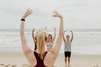 Athletic people stretching at the beach