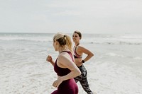 Happy sporty women jogging by the seaside
