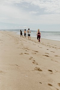 Happy friends jogging together at the beach