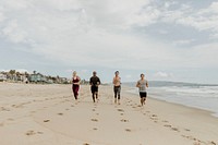Happy friends jogging together at the beach