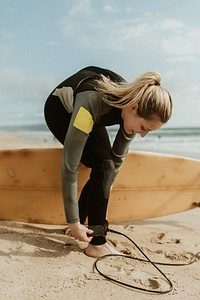 Happy woman wearing a surfboard leash