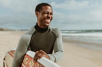 Cheerful man with a surfboard at the beach