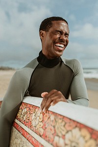 Cheerful man with a surfboard at the beach