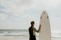 Man with a surfboard looking at the sea
