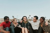Cheerful friends hugging on the beach