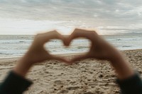 Heart shaped hand on the beach