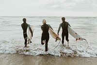 Surfers running towards the sea