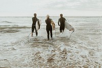 Surfers running towards the sea