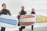 Cheerful friends surfing at the beach