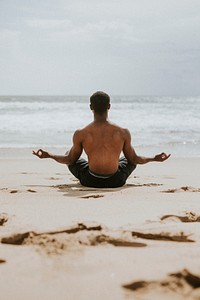 Black man meditating at the beach