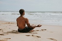 Black man meditating at the beach