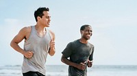 Happy friends jogging at the beach together