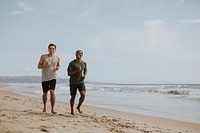 Happy friends jogging at the beach together