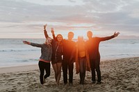 Happy friends enjoying the beach at sunset