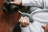 Man cleaning his camera lens with a rubber air blower