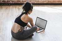 Active woman practicing yoga using a laptop