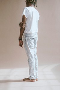 Black man standing by a beige background