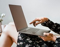 Woman at home pointing at a laptop screen