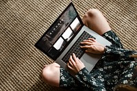 Woman on a wicker mat using a laptop