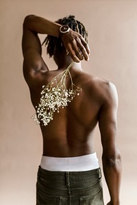 Black man carrying a bouquet of flowers on his back