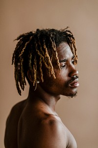 Black man posing by a beige background