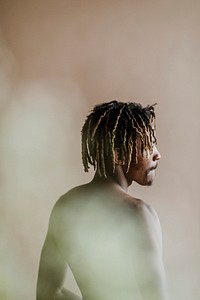 Black man posing by a beige background