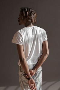 Black man standing by a gray background