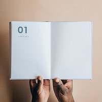 Black man holding a book planner mockup