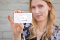 Cheerful white woman showing her business card mockup