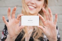 Cheerful white woman showing her business card mockup