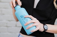 Woman carrying a thermal bottle mockup