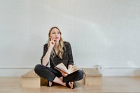 Woman thinking while writing on her notebook