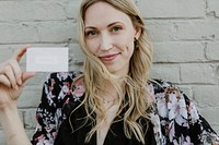 Cheerful white woman showing her business card