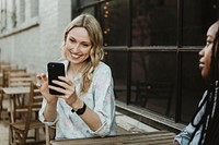 Black woman getting bored of her blond friend keep taking a selfie