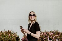 Cheerful woman with  a sunglasses texting on her phone