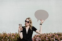 Woman showing a blank speech bubble while using her phone