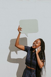 Cheerful black woman showing a blank speech bubble while talking on a phone
