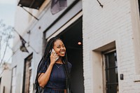 Happy black woman talking on the phone while walking on the streets