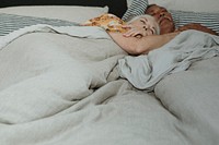 Elderly couple sleeping on a bed